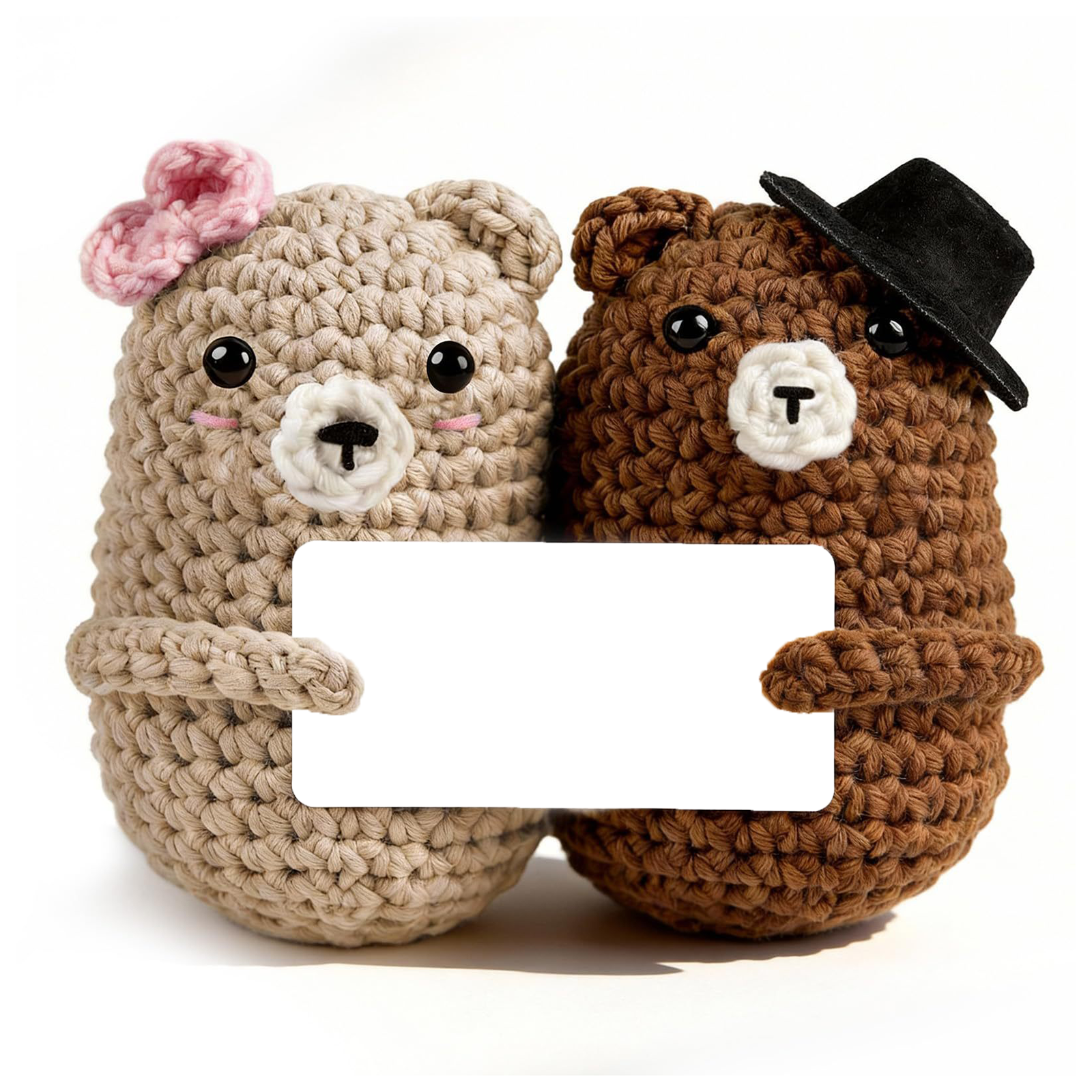 Two real crochet wedding bears, one with a pink bow and one with a black top hat, holding a blank message card