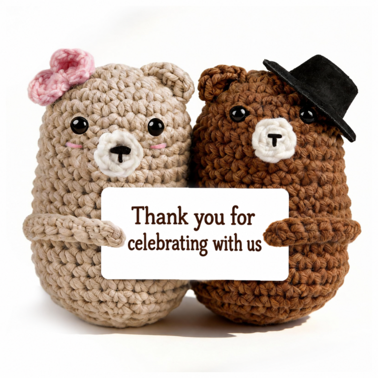 Two crochet wedding bears holding a card that reads “Thank you for celebrating with us”